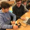 Elever sitter ved bærbar PC og arbeider med koding