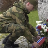 Soldat legger ned blomsterkrans.