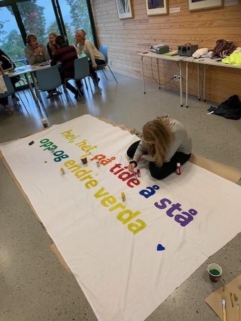 Elev sitter på gulvet og laget en stor plakat  - Klikk for stort bilde