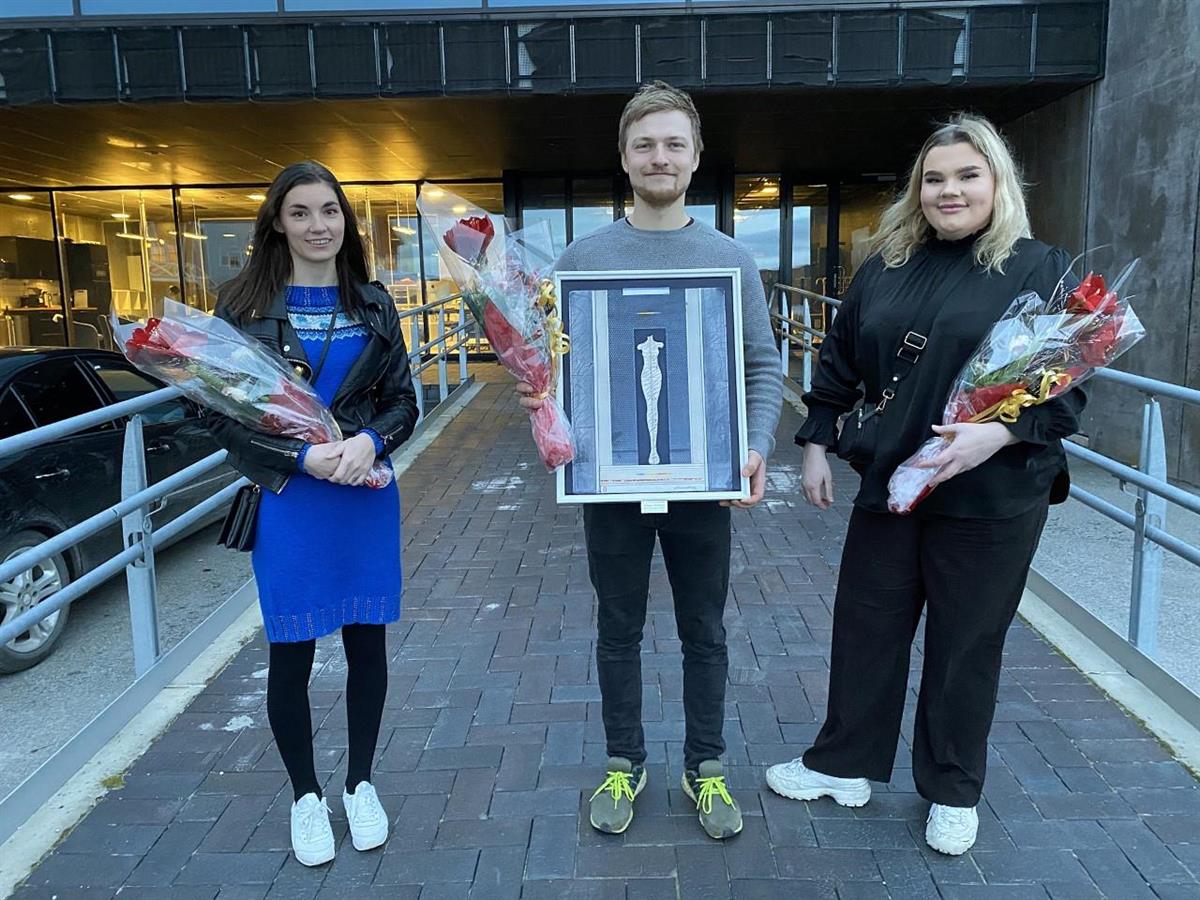 Vinnere av Namsos kommunes frivillighetspris 2020, "ungdommene på Jøa". På bildet representert av Maja Eid Schei, Kristine Schei og Halstein Tranås. De har blomsterbuketter og et bilde av Dahlslett - Klikk for stort bilde