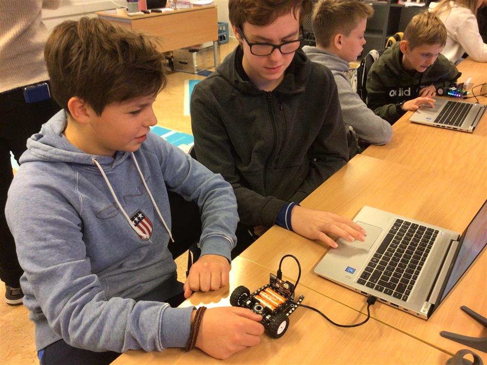 Elever sitter ved bærbar PC og arbeider med koding - Klikk for stort bilde