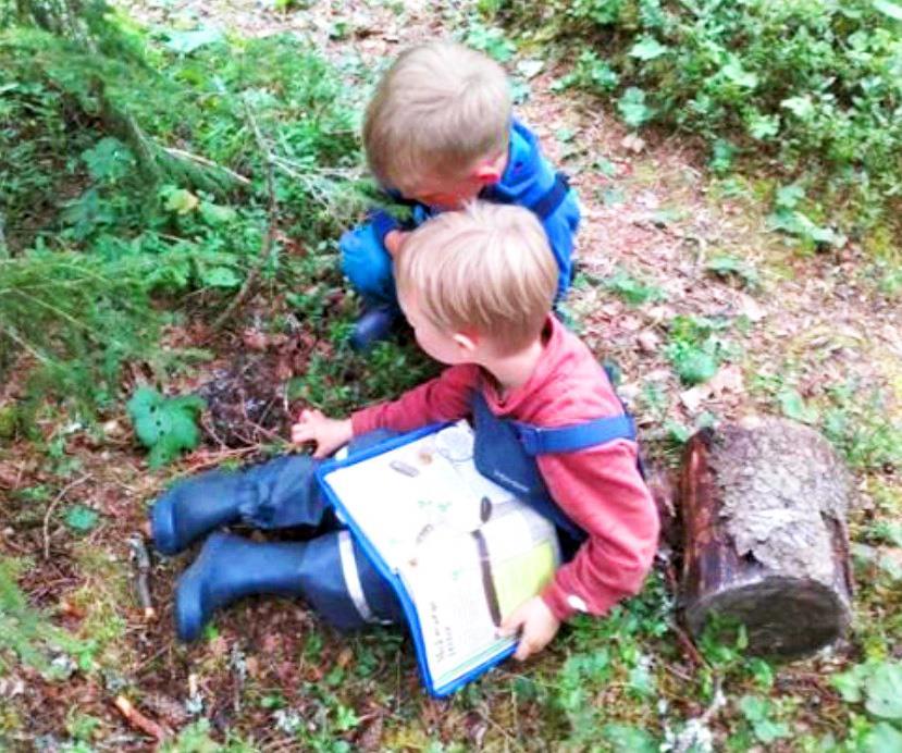 To barn sitter på en sti i skogen. - Klikk for stort bilde